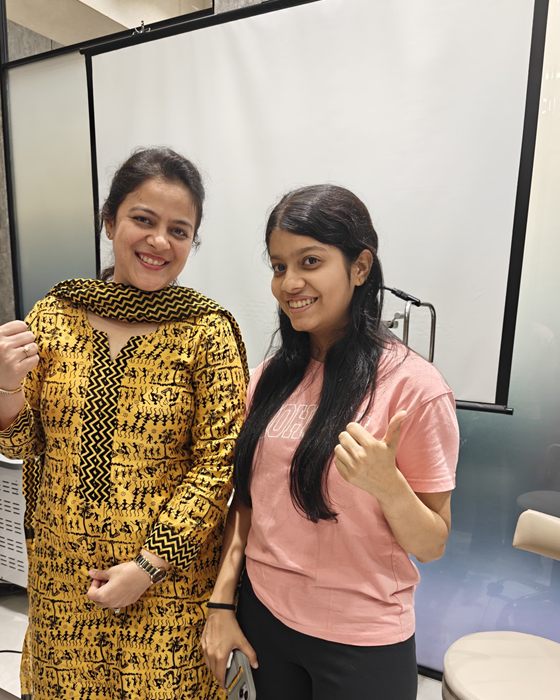A young patient with Dr. Nikita Mashru giving a thumbs up after her procedure