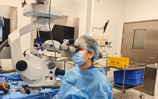Dr. Nikita Mashru operating at the microscope in the eye theatre